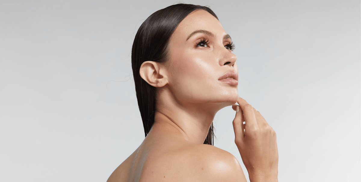 Woman with clear glowing skin and defined jawline, illustrating skin quality and facial appearance benefits in a looksmaxxing with red light therapy blog.